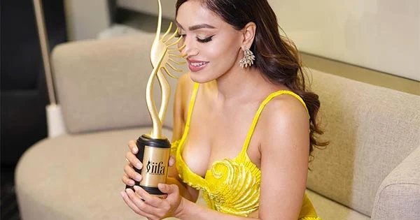 Khushali Kumar in a cleavage baring yellow dress revealing her sexy legs posed with her IIFA trophy – see now.